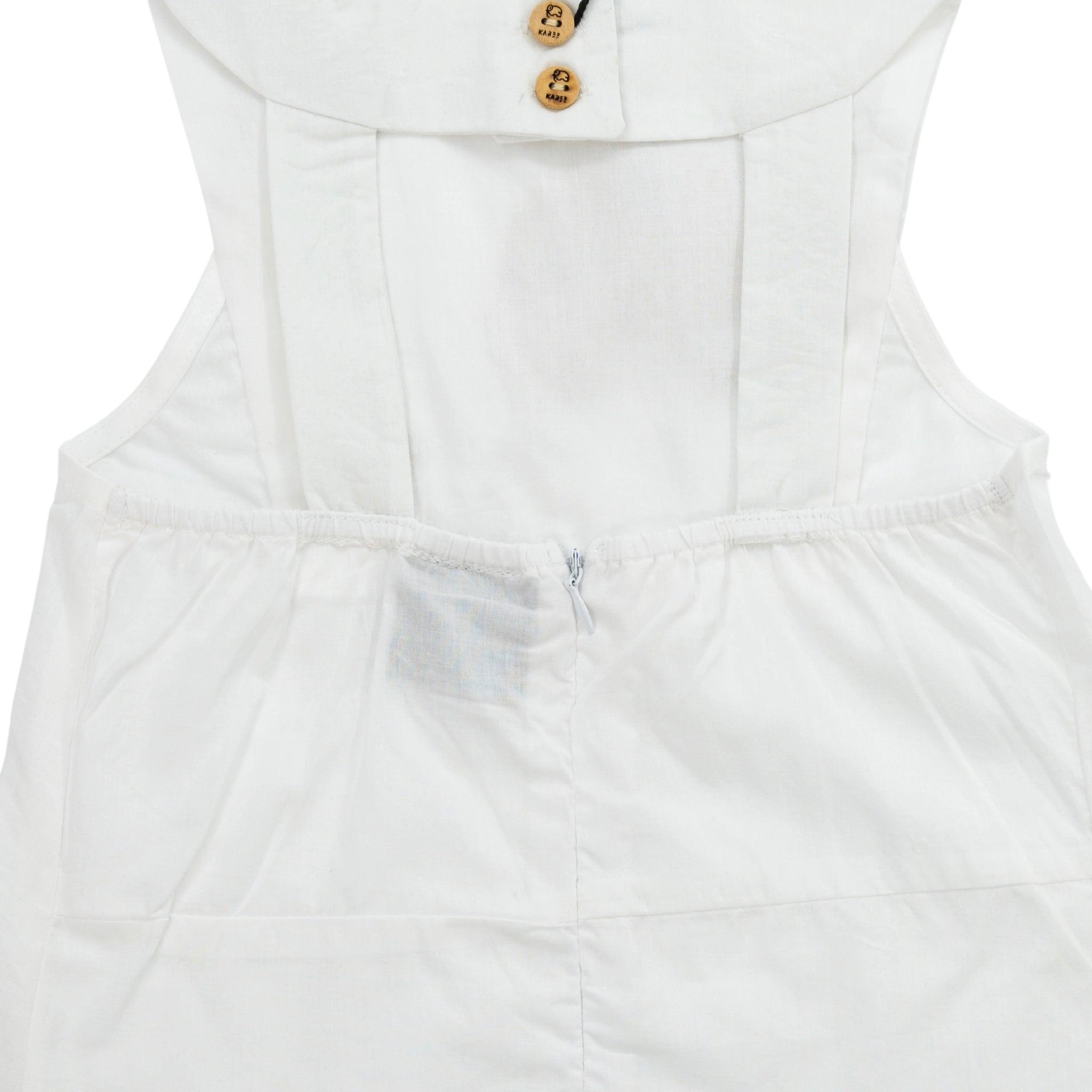 Close-up of a Karee brilliant white cotton bib neck top for kids with detailed high collar and wooden buttons, highlighting the back zipper.