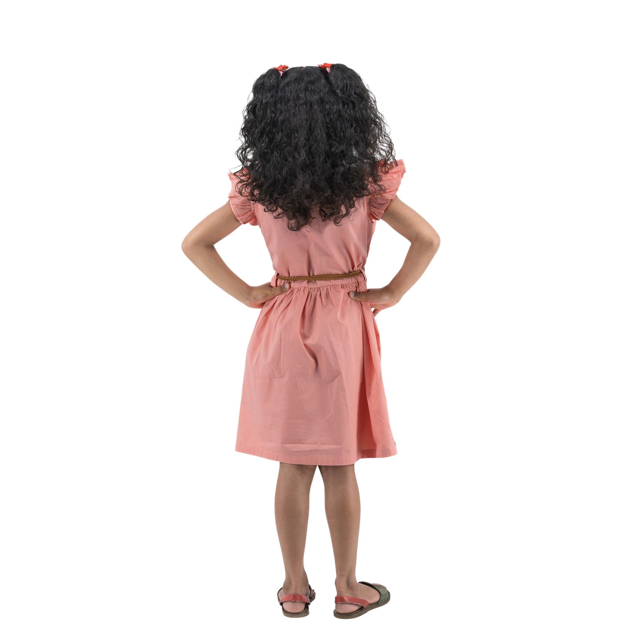 A girl in a Karee Peach & Cream Butterfly Sleeve Cotton Dress with curly hair standing with her hands on her hips, viewed from behind, isolated on a white background.