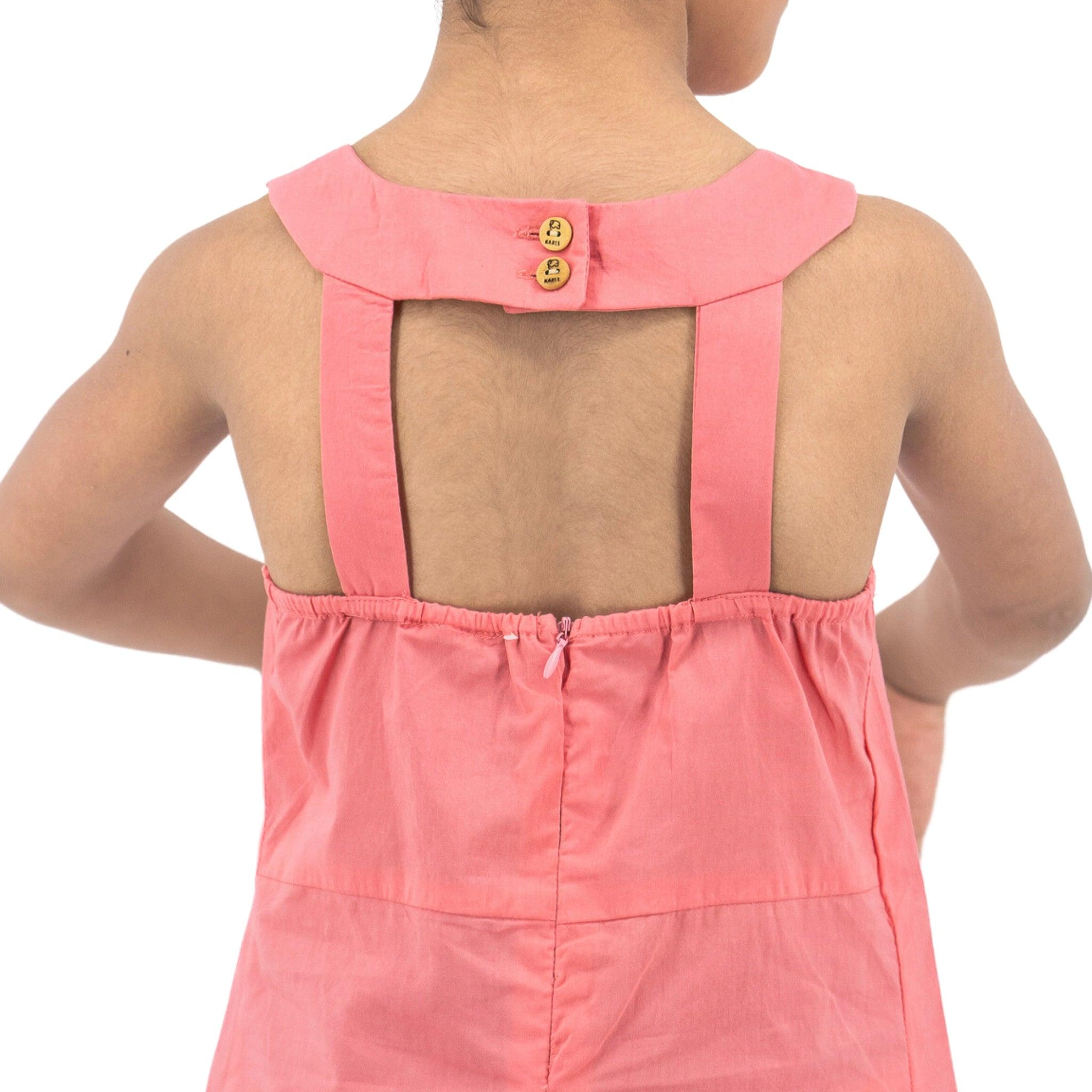 Rear view of a person wearing a Karee Tea Rose Cotton Bib Neck Top for kids with a collar button detail and a back zipper.