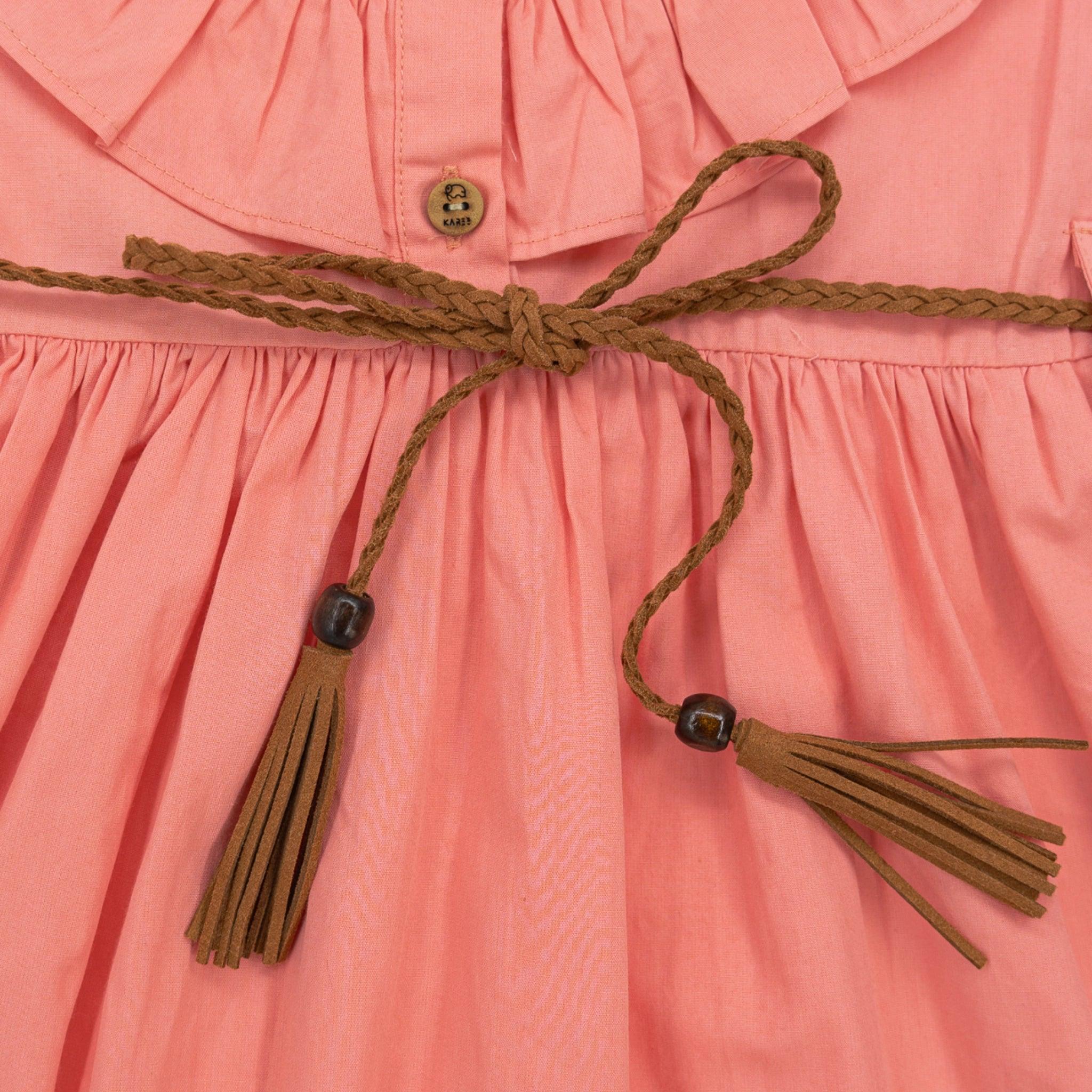 Close-up of a Karee Peach & Cream Butterfly Sleeve Cotton Dress with a braided belt featuring tassels and Karee wooden buttons.