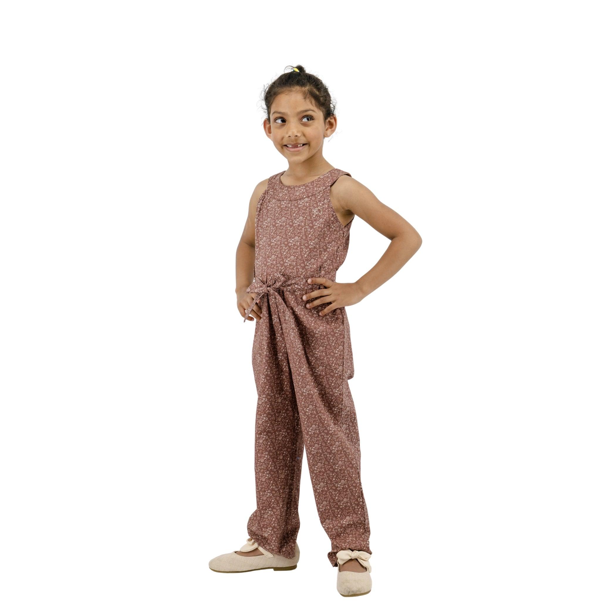 A young girl in a Karee Cocoa Brown Cotton Jumpsuit for Girls poses confidently with her hand on her hip, standing against a white background.