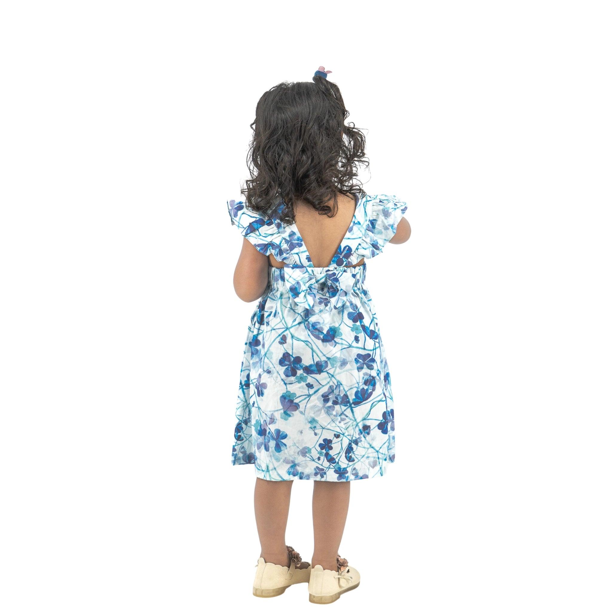 Young girl in a Karee Blue Cotton Floral Dress for Girls seen from the back, standing against a white background.