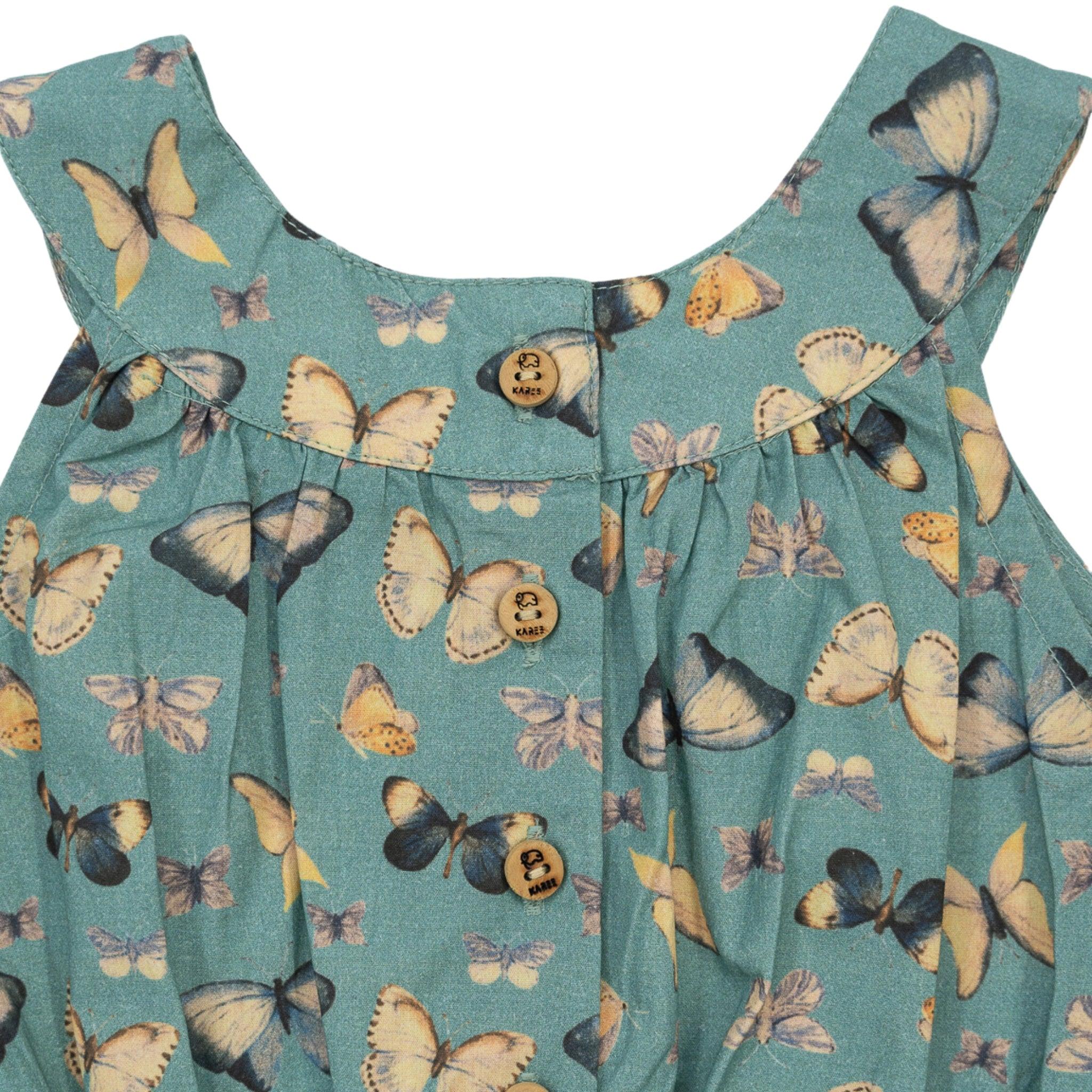 Close-up of a Blue Surf Adventure-ready Cotton Play Suit with a butterfly print and wooden buttons by Karee.