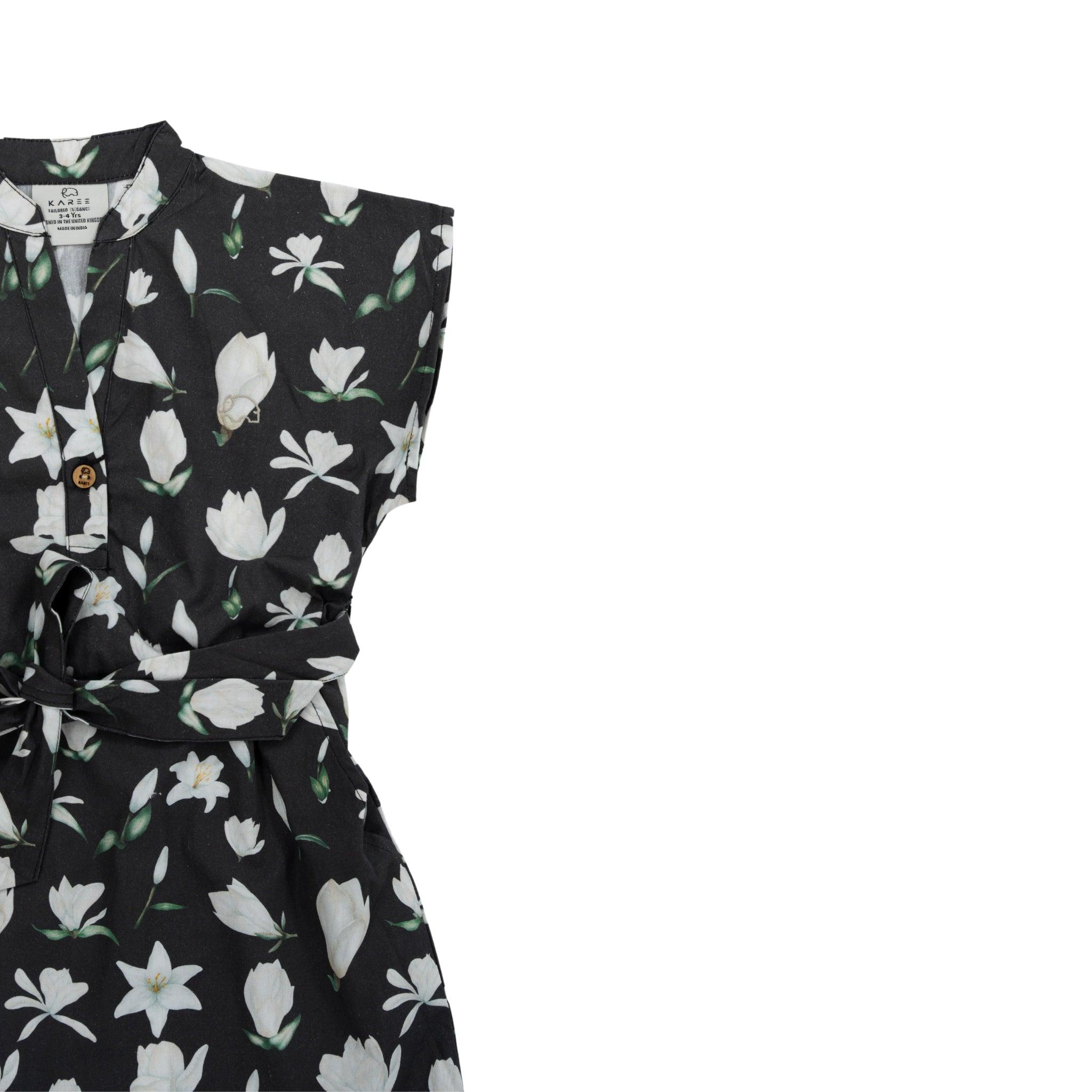 A Black Lilly Blossom cotton shirt dress with white flower prints and a waist tie, displayed against a white background.