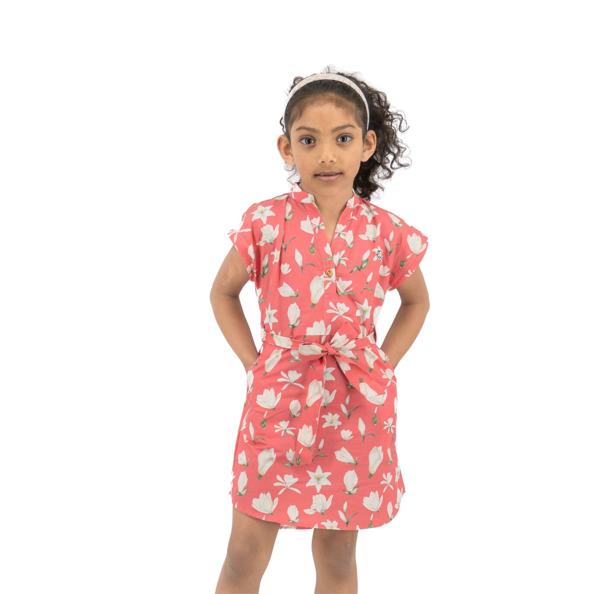 Young girl in a premium cotton, Mineral Red Lilly Blossom Karee Shirt Dress standing with hands on hips, looking slightly to the side, against a white background.