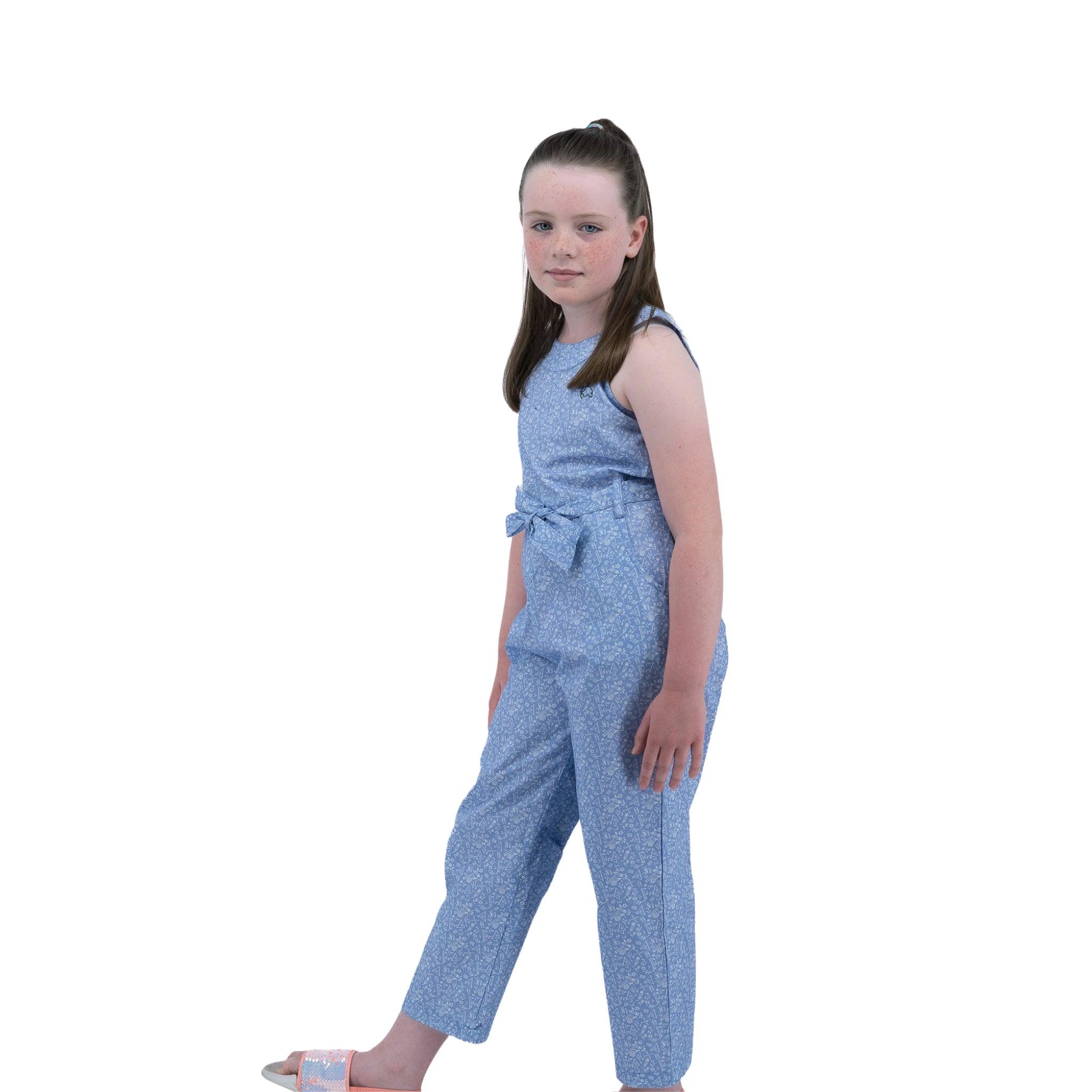 A young girl in a Karee Purple Impression Cotton Jumpsuit for kids stands sideways, looking over her shoulder, with a white background.