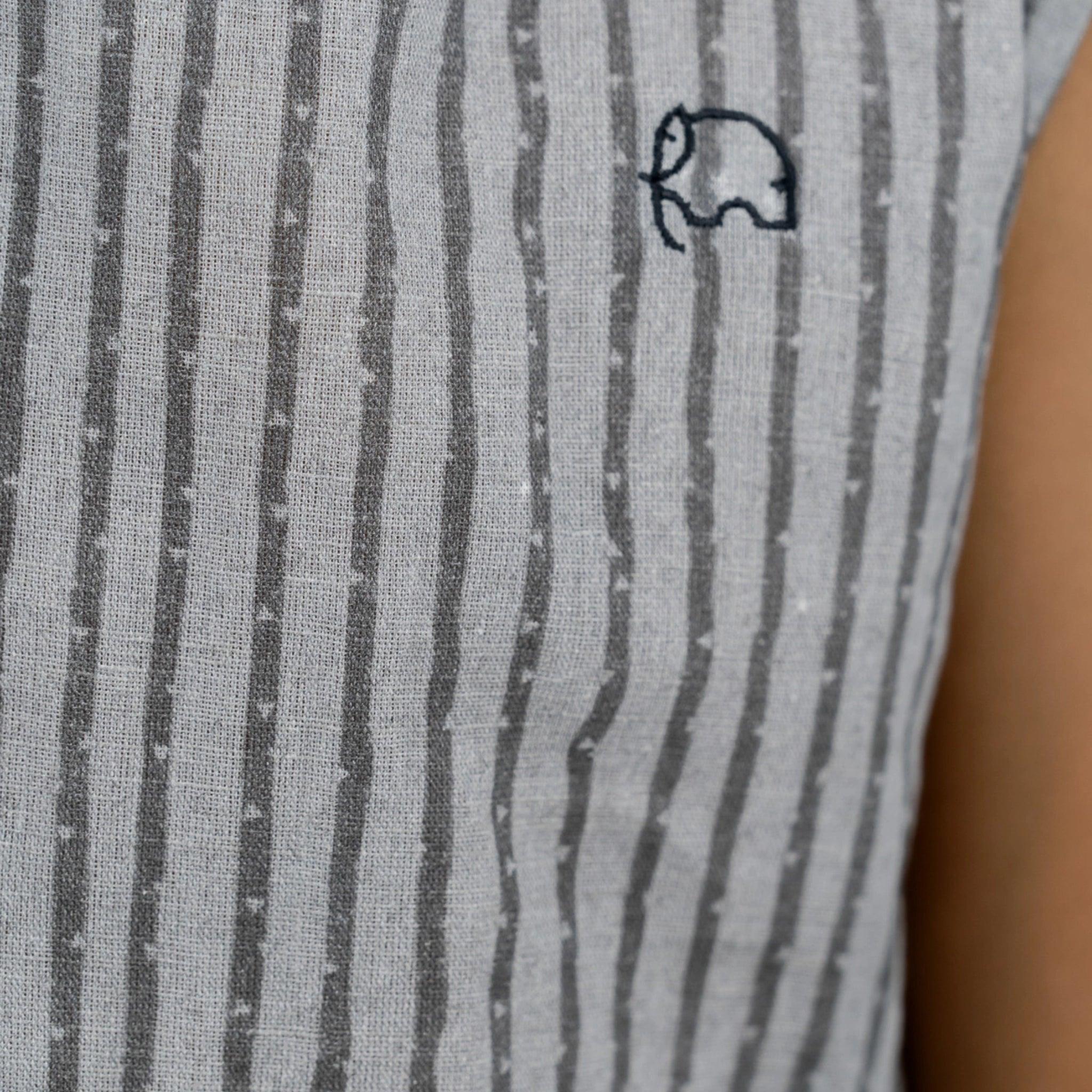 Close-up of a Karee linen cotton round neck frock for kids in steel grey with a small black embroidered elephant on a sleeve, epitomizing children's fashion.