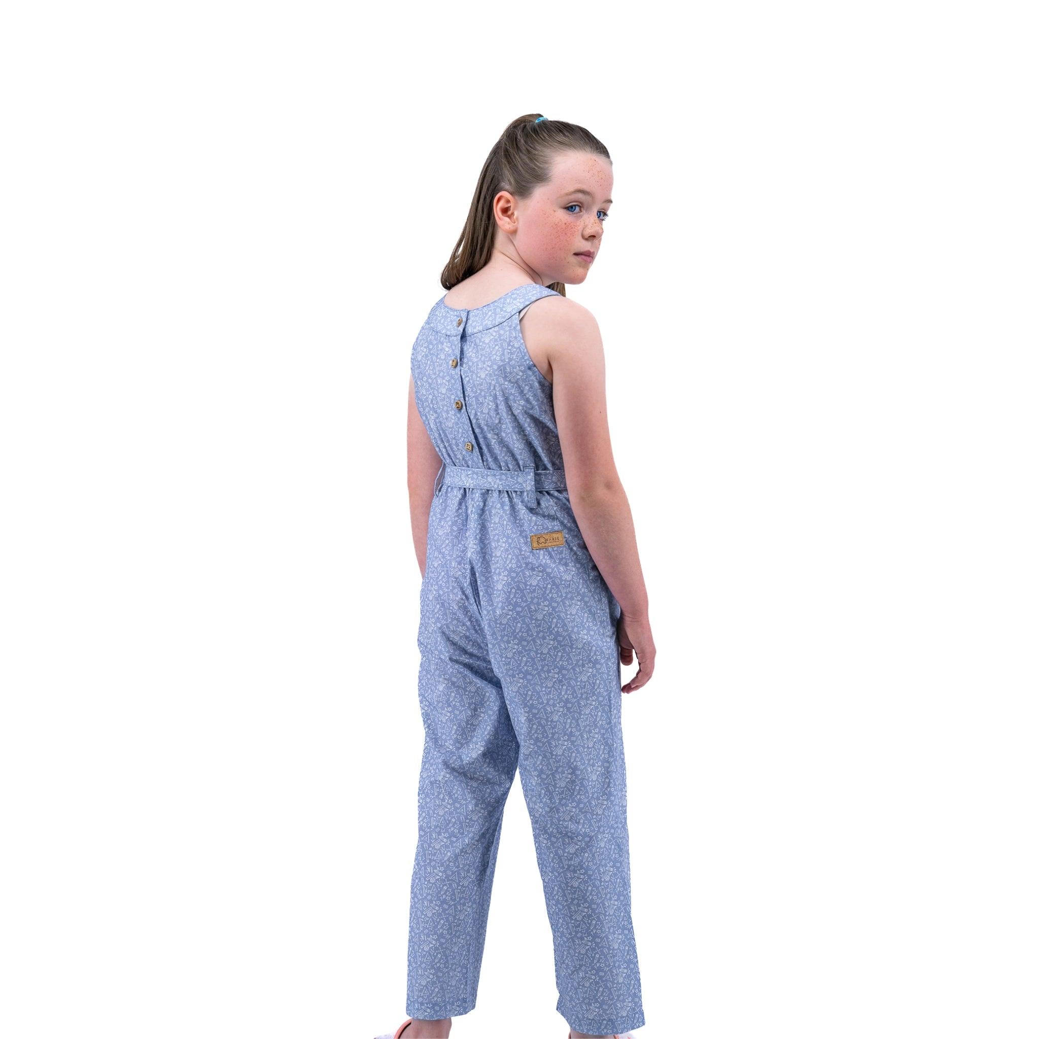 Young girl in a Karee Purple Impression Cotton Jumpsuit looking over her shoulder against a white background.