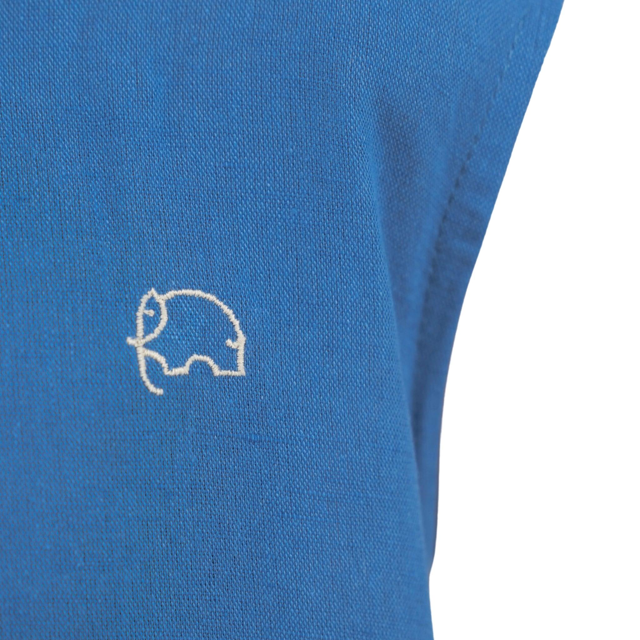 Close-up of a Karee linen cotton round neck frock for kids in Vallarta blue fabric with a small white embroidered logo of a stylized pig on the lower right corner.