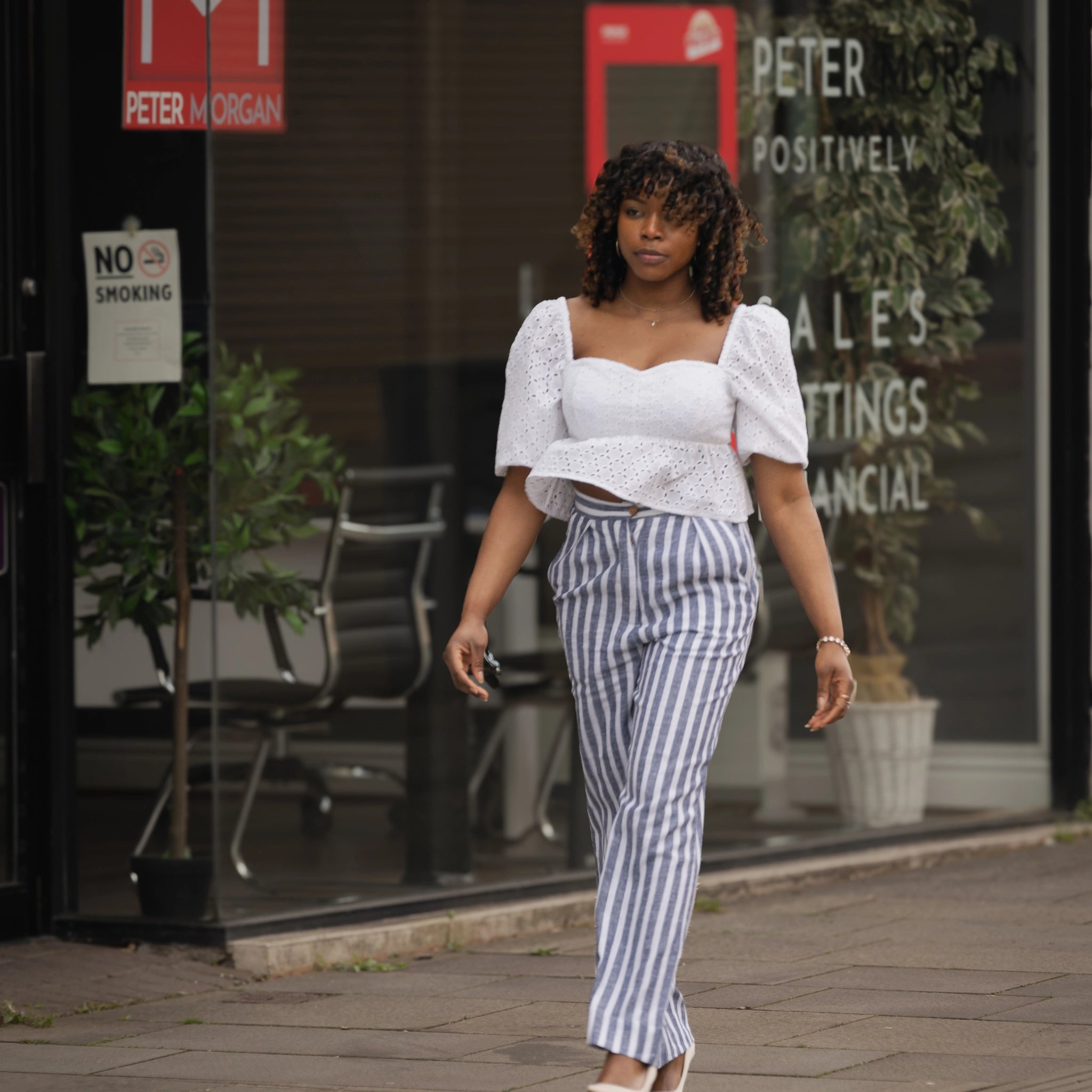 woman walking through streets of london wearing a Monochrome Chic Linen Trousers and white lace top