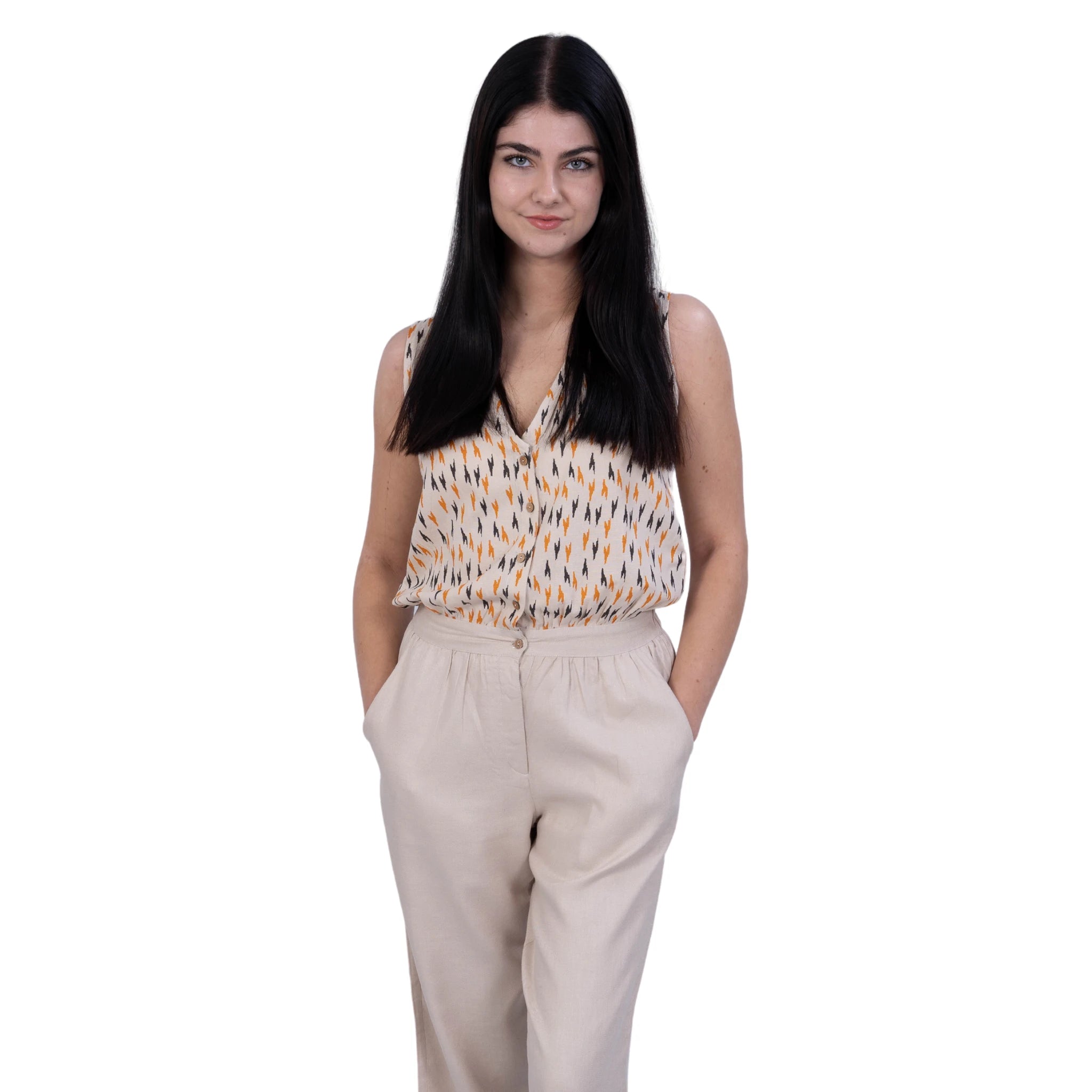 A woman wearing a linen jumpsuit, dual colour, Beige and Chevron print. Sleeveless jumpsuit. Girl with black hair. Jumpsuit with pockets