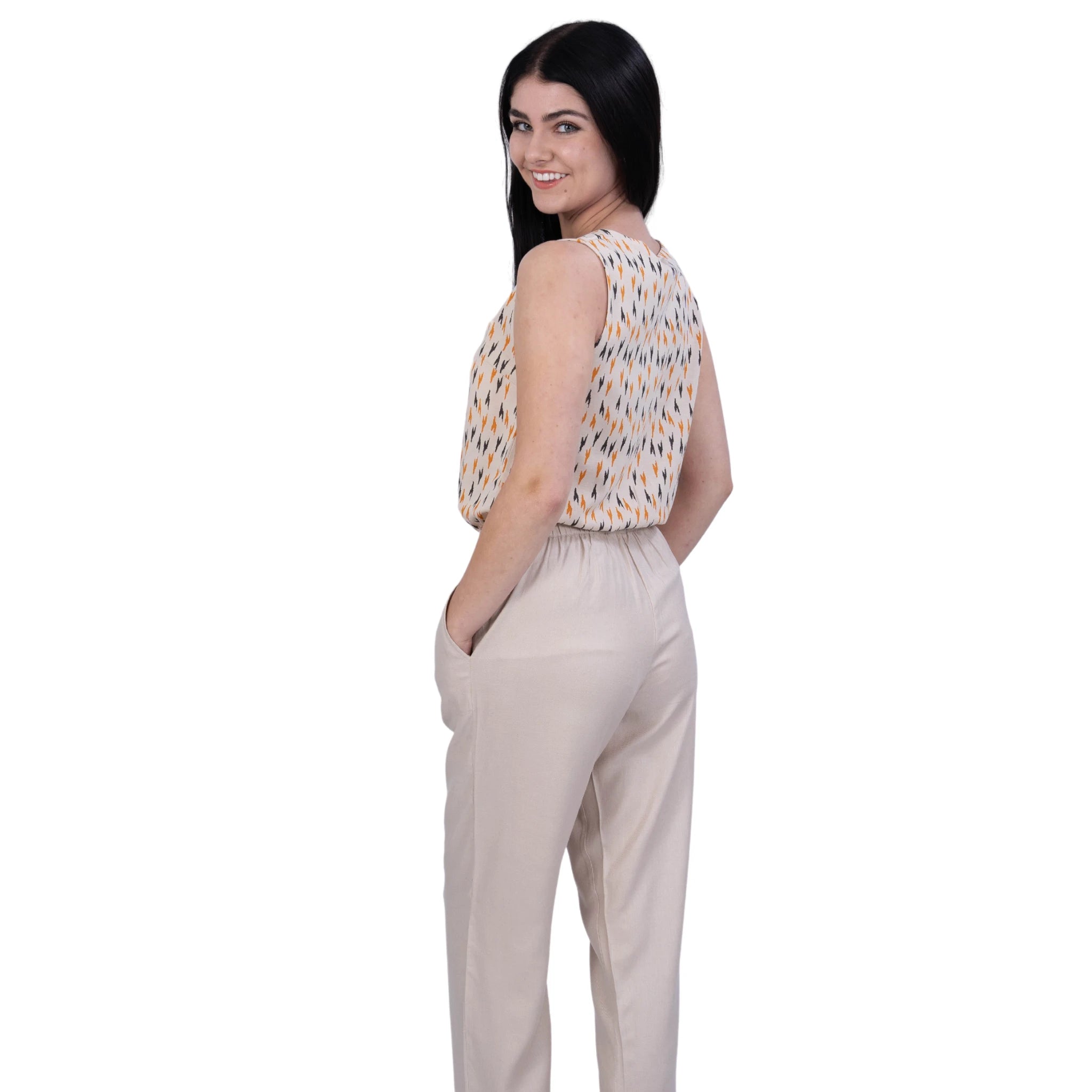 A woman wearing a Beige jumpsuit, Linen comfort, Woman looking back into camera. Printed jumpsuit