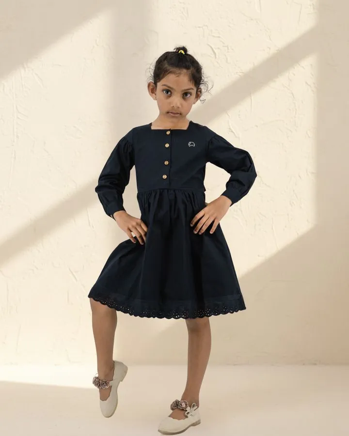 Girls' autumn dress: a girl posing in the Navy long puff-sleeve cotton dress with square neck and wooden buttons