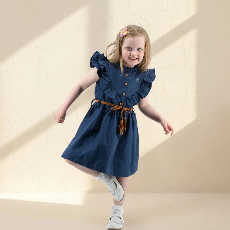 The Ruffle Dress in Navy, worn by a child